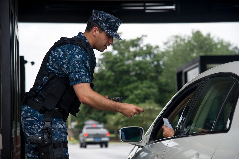 Petty Officer Third Class James Use, an electrician’s mate from the Naval Nuclear Power Training Command, assists a visitor with directions at the Dorchester Gate, July 30, 2013, at Joint Base Charleston – Air Base, S.C. Sailors along with other volunteers participated in the security forces augmentee training class which consisted of M-9 pistol qualification training and learning how to properly check identification cards, apprehend personnel and how to conduct vehicle searches. Sailors from NNPTC who are in transition or waiting on their new assignments are assisting the 628th Security Forces Squadron, maintaining base security during sequestration. (U.S. Air Force photo/Staff Sgt. Rasheen Douglas)