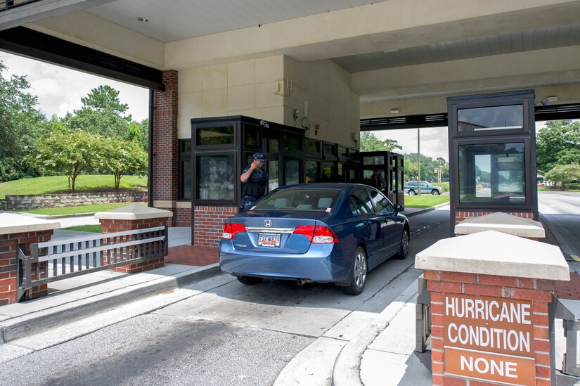 Petty Officer Third Class James Use, an electrician’s mate from the Naval Nuclear Power Training Command, salutes an officer after checking his I.D. cared and allowing him to pass through the Dorchester Road gate, July 30, 2013, at Joint Base Charleston – Air Base, S.C. Sailors along with other volunteers participated in the security forces augmentee training class which consisted of M-9 pistol qualification training and learning how to properly check identification cards, apprehend personnel and how to conduct vehicle searches. Sailors from NNPTC who are in transition or waiting on their new assignments are assisting the 628th Security Forces Squadron, maintaining base security during sequestration. (U.S. Air Force photo/Staff Sgt. Rasheen Douglas)