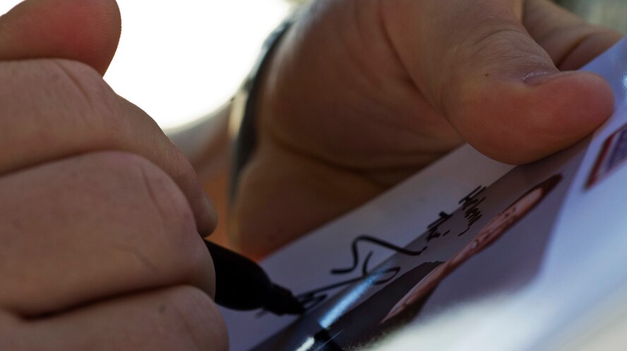 Amerian country singer Scotty McCreery signs an autograph on Minot Air Force Base, July 25. McCreery recieved a base tour the day after his USO concert for Airmen and their families. (U.S. Air Force photo/Senior Airman Brittany Y. Auld)