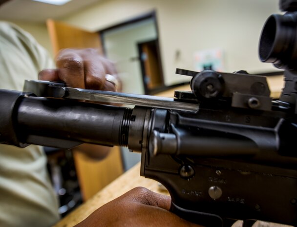 Staff Sgt. Julius Taylor, 628th Security Forces Squadron Combat Arms Training and Maintenance instructor, performs a function check function check on an M-4 carbine rifle July 30, 2013, at Joint Base Charleston – Air Base, S.C. This process ensures the disconnectors, springs, and sear are in working order. This process will validate the safety feature, semi and three round burst parts of the weapon and ensure the operator is operating a safe weapon as it is designed to perform. (U.S. Air Force photo/ Senior Airman Dennis Sloan)