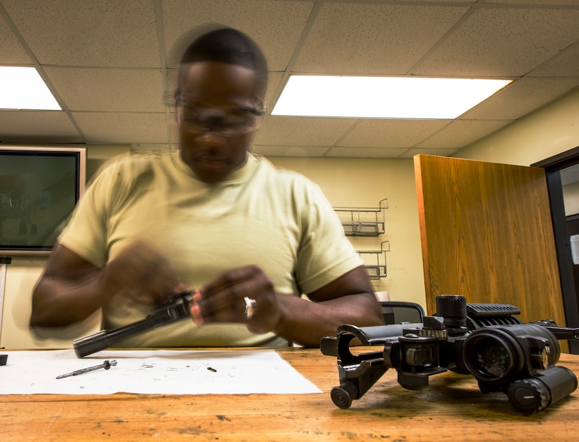 Staff Sgt. Julius Taylor, 628th Security Forces Squadron Combat Arms Training and Maintenance instructor, removes the bolt cam pin from the bolt carrier of an M-4 carbine rifle during the disassembling process July 30, 2013, at Joint Base Charleston – Air Base, S.C. CATM instructors are subject matter experts on operating, disassembling and maintaining all weapons held in the armory. (U.S. Air Force photo/ Senior Airman Dennis Sloan)