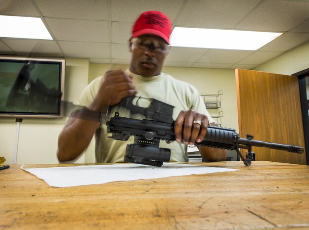 Staff Sgt. Julius Taylor, 628th Security Forces Squadron Combat Arms Training and Maintenance instructor, removes the lower receiver from the upper receiver of an M-4 carbine rifle during the disassembling process July 30, 2013, at Joint Base Charleston – Air Base, S.C. CATM instructors are subject matter experts on operating, disassembling and maintaining all weapons held in the armory. (U.S. Air Force photo/ Senior Airman Dennis Sloan)
