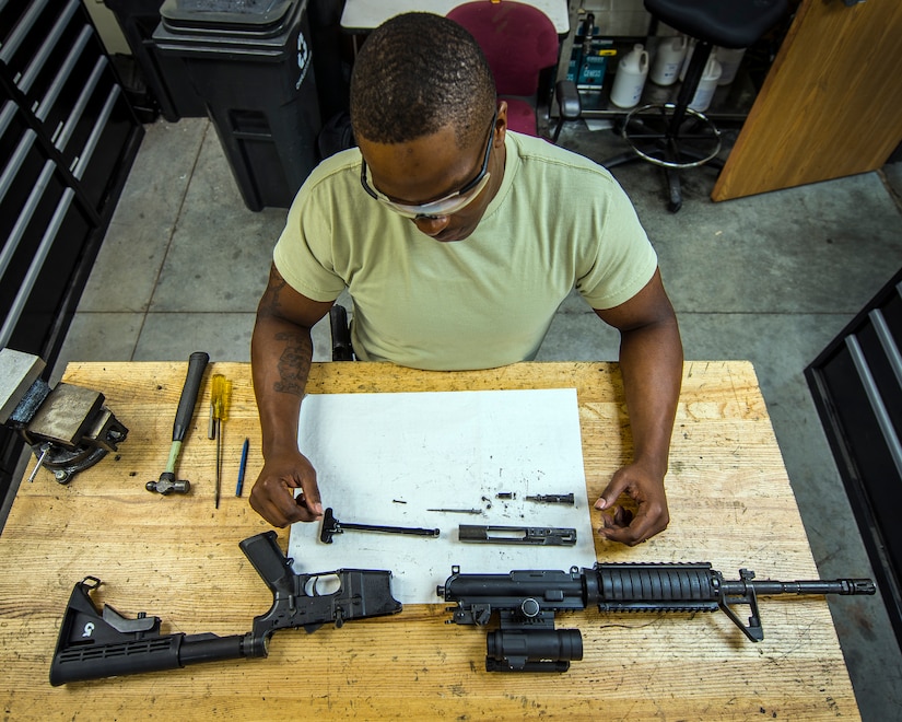 Staff Sgt. Julius Taylor, 628th Security Forces Squadron Combat Arms Training and Maintenance instructor, disassembles an M-4 carbine rifle July 30, 2013, at Joint Base Charleston – Air Base, S.C. Taylor inspects for broken or worn parts, cleans and lubricates the carbine rifle and checks the spring tension when the weapons is disassembled. CATM instructors are subject matter experts on operating, disassembling and maintaining all weapons held in the armory. (U.S. Air Force photo/ Senior Airman Dennis Sloan)