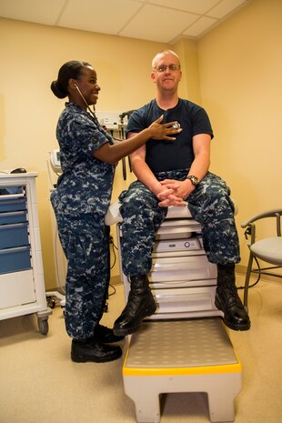 Seaman Yolanda King, Naval Health Clinic Charleston hospital corpsman, listens to Seaman Dennis Littrell’s heartbeat July 29, 2013, at Joint Base Charleston - Weapons Station, S.C. King has been in the Navy for more than two years, and has been at NHCC since May 2012. She was recently named NHCC’s Blue Jacket of the Quarter which is awarded to a junior Sailor for his or her outstanding performance during a three month period. NHCC provides quality healthcare services for approximately 12,000 beneficiaries throughout the LowCountry, including a sick call clinic for Sailors assigned to the Weapons Station. (U.S. Air Force photo/ Senior Airman George Goslin)