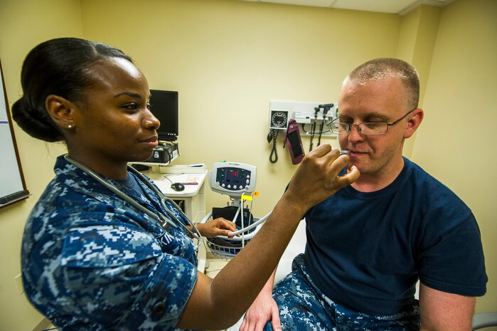 Seaman Yolanda King, Naval Health Clinic Charleston hospital corpsman, takes Seaman Dennis Littrell’s temperature July 29, 2013, at Joint Base Charleston - Weapons Station, Goose Creek, S.C. King has been in the Navy for more than two years, and has been at NHCC since May 2012. She was recently named NHCC’s Blue Jacket of the Quarter which is awarded to a junior Sailor for his or her outstanding performance during a three month period. NHCC provides quality healthcare services for approximately 12,000 beneficiaries throughout the LowCountry, including a sick call clinic for Sailors assigned to the Weapons Station. (U.S. Air Force photo/ Senior Airman George Goslin)