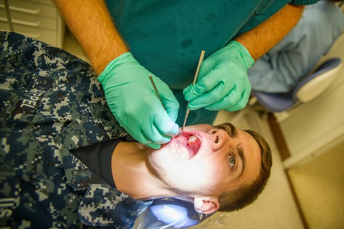 Lt. Cmdr. Joshua Henson, Naval Health Clinic Charleston senior dental executive, examines a patient July 29, 2013, at Joint Base Charleston - Weapons Station, Goose Creek, S.C. NHCC provides quality healthcare services for approximately 12,000 beneficiaries throughout the LowCountry, including a sick call clinic for Sailors assigned to the Weapons Station. (U.S. Air Force photo/ Senior Airman George Goslin)