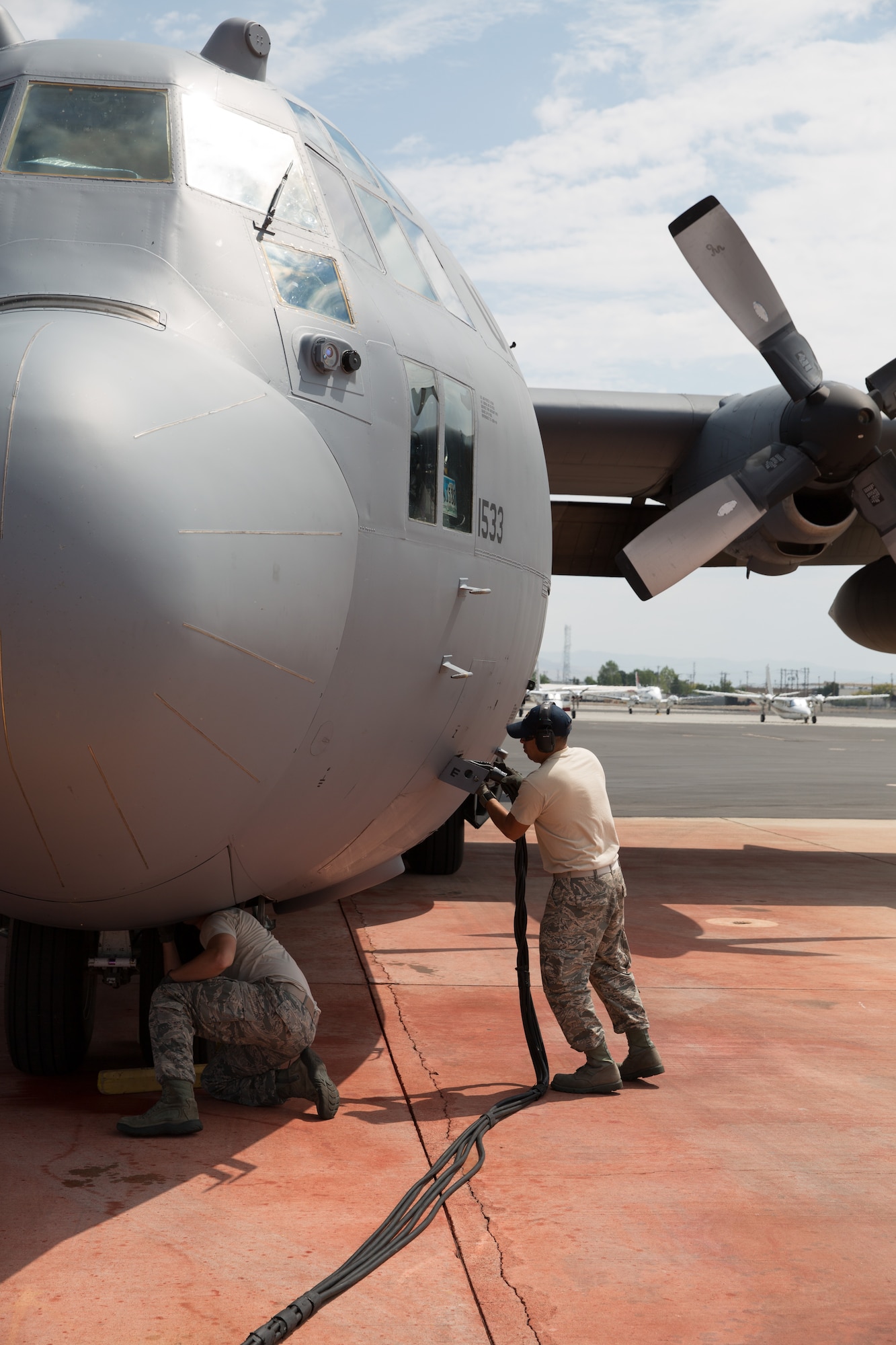 Staff Sgt. Carlos Alvarado and Staff Sgt. Norman Strand prepare a Modular Airborne Fire Fighting System-equpped C-130 from the 153rd Airlift Wing to take off in Boise, Idaho on July 28, 2013. Wyoming and North Carolina Air National Guard units are currently based at Boise in support of MAFFS missions. (U.S. Air National Guard photo by Tech. Sgt. Jeffrey Allred)