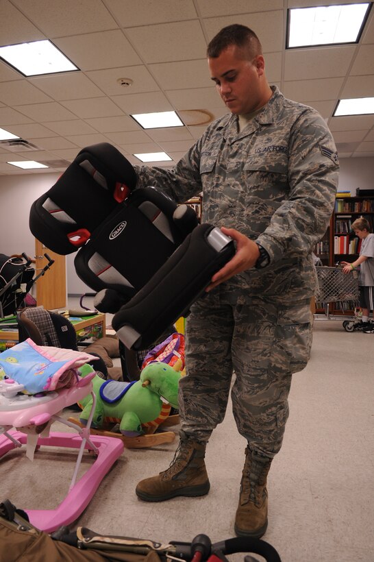 Senior Airman Steele Britton, Air Force District of Washington Headquarters Staff, looks at a car seat for his son, along with other inventory available at the Andrews Attic at Joint Base Andrews, Md., July 30, 2013. The Andrews Attic is open to active-duty service members, E-5 and below, and their dependents, and is open Tuesdays and Fridays from 12 p.m. to 4 p.m.