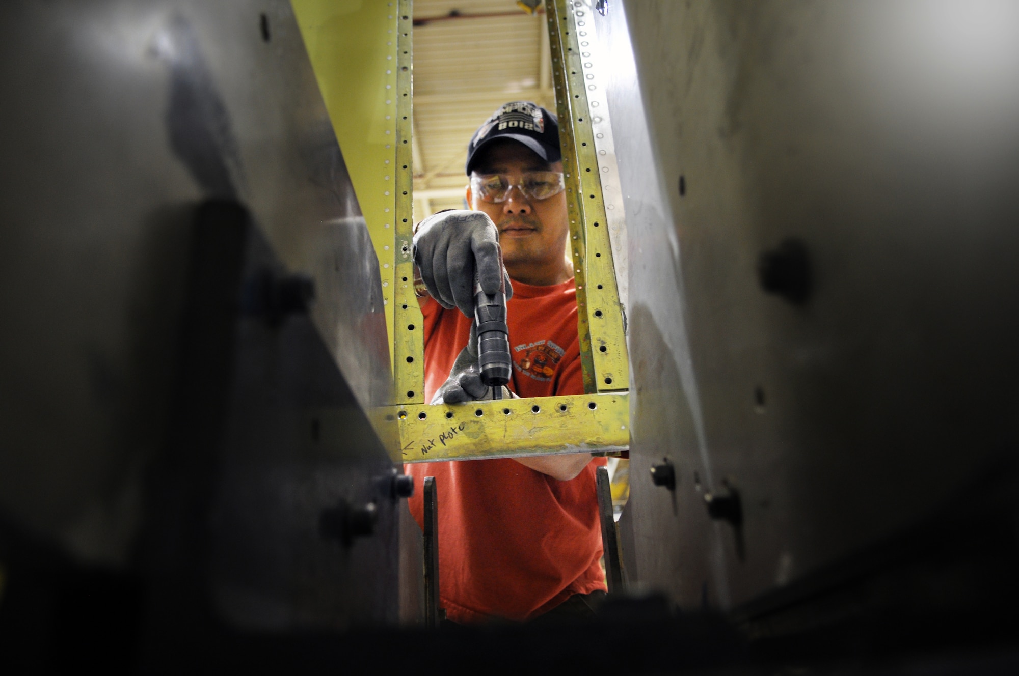 Thien M. Le, a sheet metal mechanic with the 76th Commodities Maintenance Group, drills a section of the rudder in preparation for a new PCU fitting. (Air Force photo by Micah Garbarino)