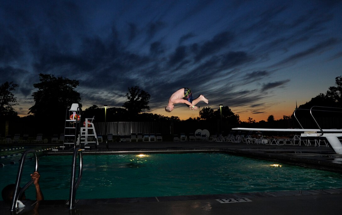 Airman 1st Class Jacob Stoner, 89th Operations Support Squadron airfield management operations coordinator, jumps off the diving board during Airmen Summer Pool Block Party at Joint Base Andrews, Md., July 26, 2013. Airmen Committed to Excellence hosted the reverse potluck style party for all Airmen grades E-1 through E4. (U.S. Air Force photo/ Airman 1st Class Nesha Humes)