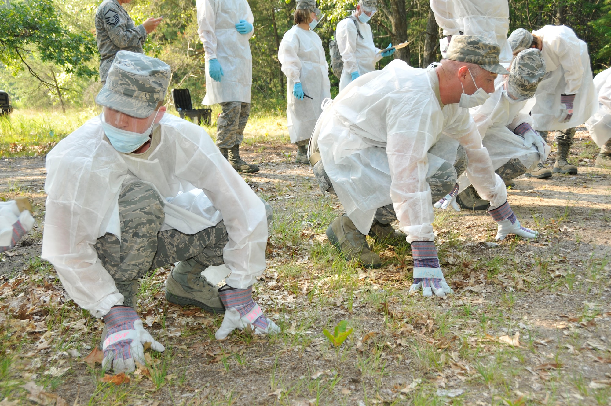 U.S. Airmen with the Indiana Air National Guard, 181st Intelligence Wing Force Support Squadron examine the terrain searching for simulated remains during a fatality search and rescue exercise July 16, 2013, at the Combat Readiness Training Center, Alpena, Mich. (U.S. Air National Guard photo by Senior Master Sgt. John S. Chapman/Released)