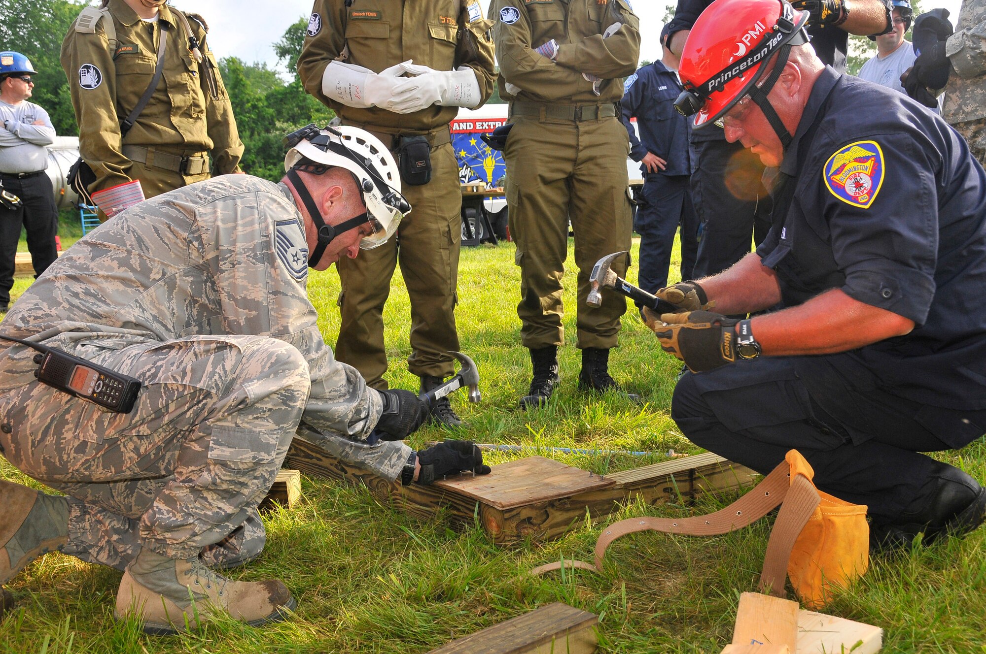 Air Force Master Sgt. Sean S. Fretwell, 181st Intelligence Wing, 19th CERFP, together with a Bloomington fire fighter, constructs a wall brace to support an entrance to a building at Camp Atterbury, Edinburgh, Ind., June 10, 2013. The training conducted at Camp Atterbury involved Air and Army Guardsmen, Bloomington Fire Department and Israelis Search and Rescue team in an exercise called United Front II. (U.S. Air National Guard photo by Senior Master Sgt. John S. Chapman/Released)