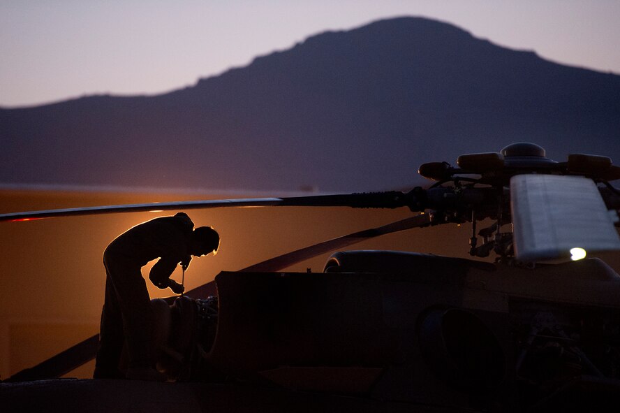 An Afghan air force maintenance technician, illuminated by a hanger light, preflights an Mi-17 for an early morning take off July 21, 2013, from Kabul International Airport, Afghanistan. Intermediate maintenance inspection advisers from the 440th Air Expeditionary Advisory Squadron are focusing efforts on building stronger quality control programs across Afghan air force aircraft maintenance. (U.S. Air Force photo/Master Sgt. Ben Bloker)