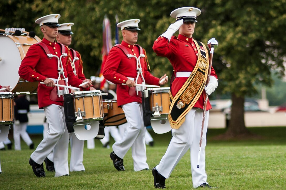 Sgt. Courtney Lawrence, U.S. Marine Drum & Bugle Corps parade drum major, salutes while passing in review during a Tuesday Sunset Parade at the Marine Corps War Memorial in Arlington, Va., July 30. Noncommissioned officers marched in positions traditionally held by officers and staff noncommissioned officers during this parade.