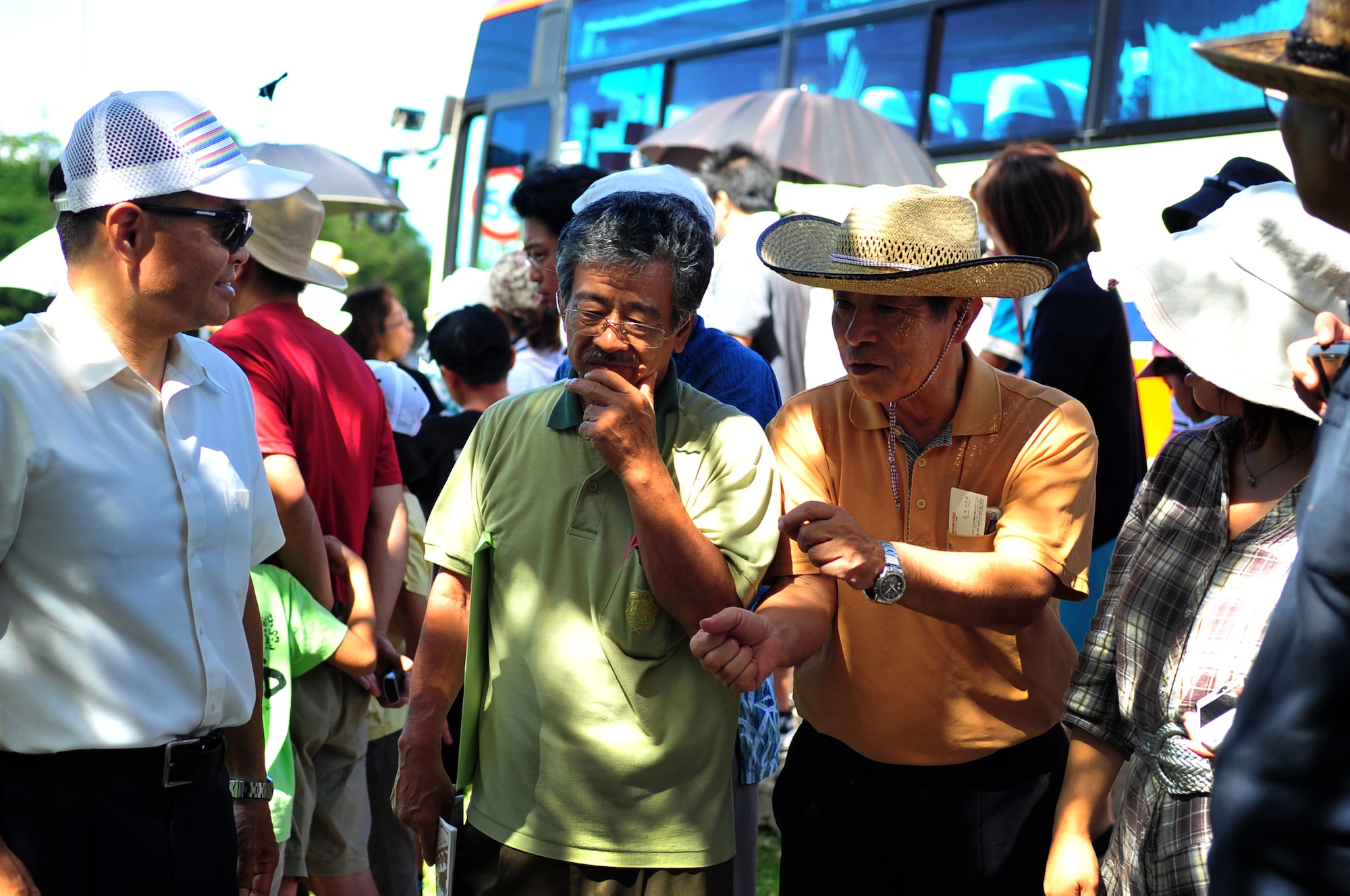 Hideaki Sakihama, 18th Wing Public Affairs community relations specialist, speaks with Okinawa City citizens about the history of the World War II Japanese aircraft hangars on Kadena Air Base, Japan, July 30, 2013. This tour was part of an annual peace campaign that the city has where residents visit war-related sites both on and off base to provide a chance for city citizens to think about the importance of peace. (U.S. Air Force photo by Senior Airman Amber E. N. Jacobs/Released)