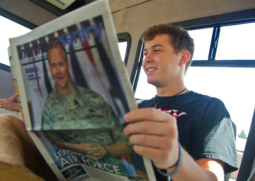 Amerian country singer Scotty McCreery reads an edition of the Northern Sentry at Minot Air Force Base, N.D., July 25. McCreery recieved a base tour the day after his USO concert for Airmen and their families. (U.S. Air Force photo/Senior Airman Brittany Y. Auld)