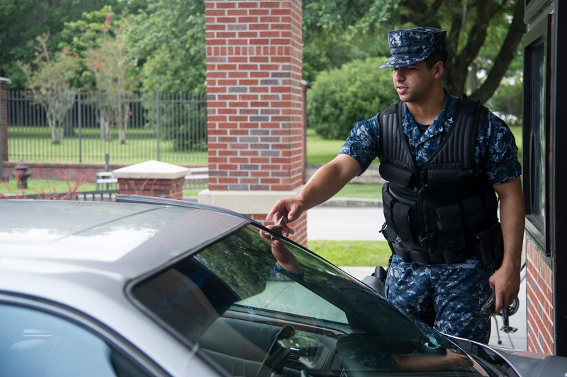 Petty Officer Third Class James Use, an electrician’s mate from the Naval Nuclear Power Training Command, checks an identification card July 30, 2013, at Joint Base Charleston – Air Base, S.C. Sailors along with other volunteers participated in the security forces augmentee training class which consisted of M-9 pistol qualification training and learning how to properly check identification cards, apprehend personnel and how to conduct vehicle searches. Sailors from NNPTC who are in transition or waiting on their new assignments are assisting the 628th Security Forces Squadron, maintaining base security during sequestration. (U.S. Air Force photo/Staff Sgt. Rasheen Douglas)