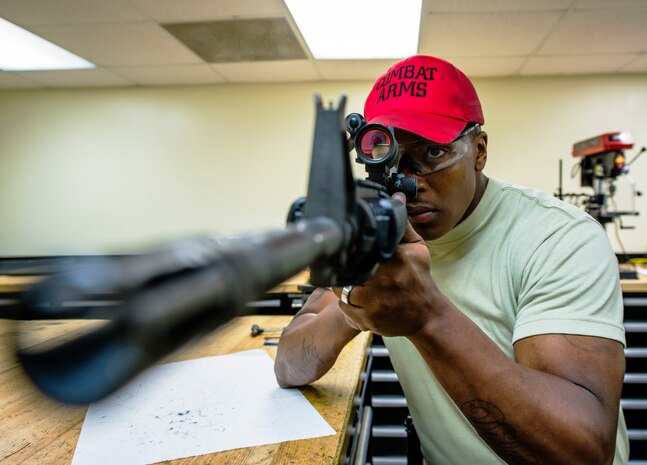 Staff Sgt. Julius Taylor, 628th Security Forces Squadron Combat Arms Training and Maintenance instructor, looks through the M68 Close Combat Optic scope of an M-4 carbine rifle to ensure all settings are working properly July 30, 2013, at Joint Base Charleston – Air Base, S.C. CATM instructors are subject matter experts on operating, disassembling and maintaining all weapons held in the armory. (U.S. Air Force photo/ Senior Airman Dennis Sloan)