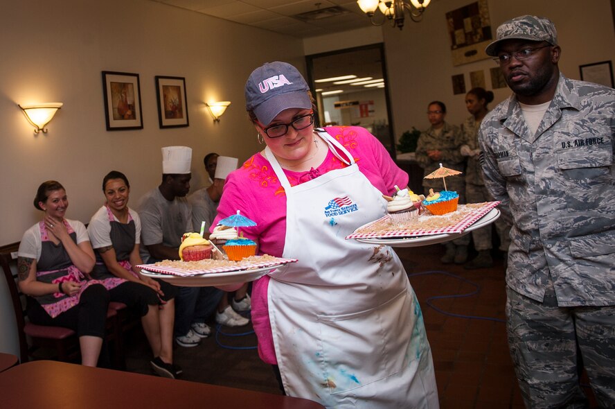 Rachael Holder, Tasty Tigers team member, brings her team’s cupcakes to the judging table during Cupcake Wars 3 at Moody Air Force Base, Ga., July 23, 2013. Tasty Tigers won their third straight victory at Cupcake Wars 3. (U.S. Air Force photo by Senior Airman Jarrod Grammel/Released)
