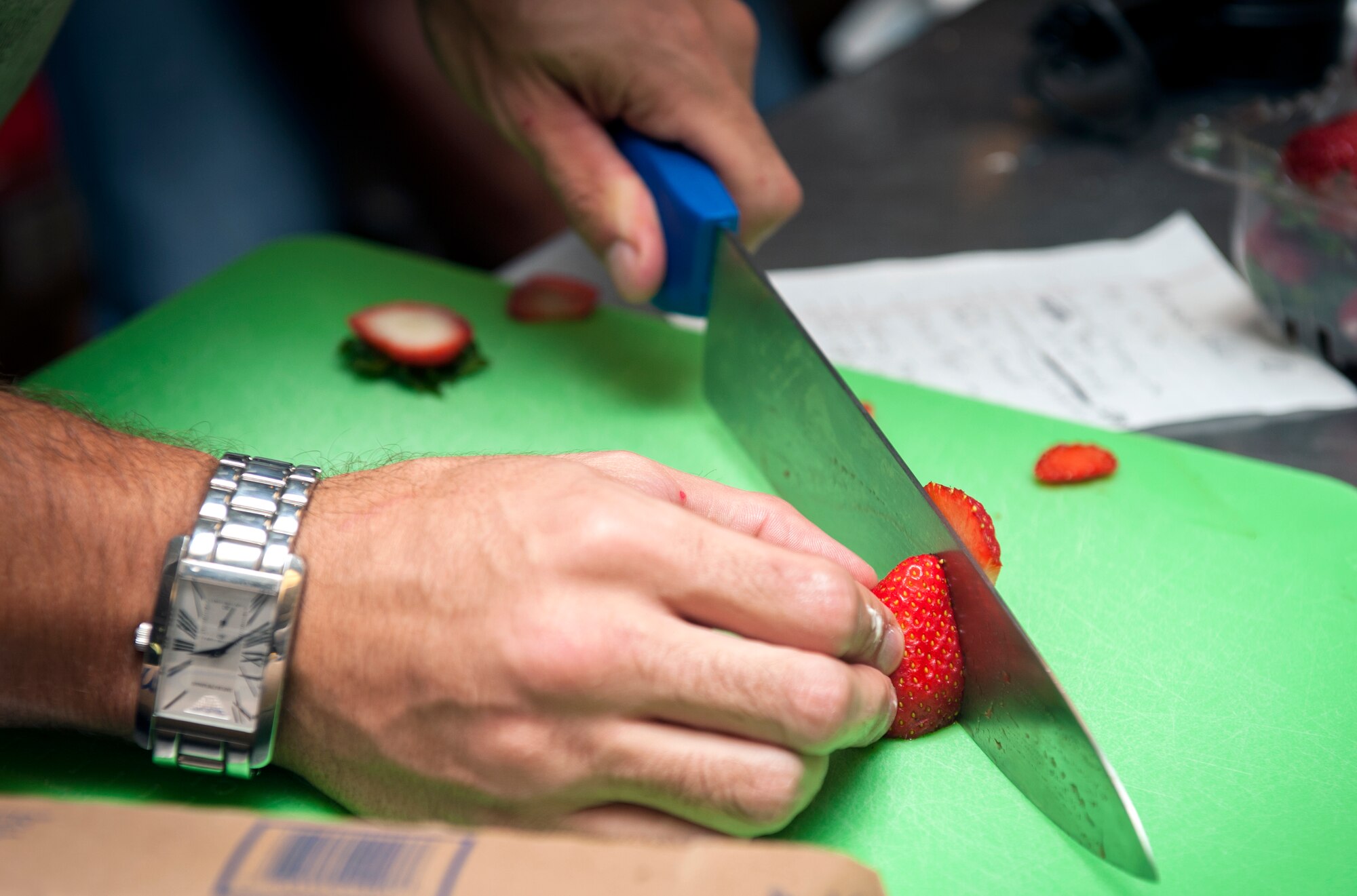 An Airman cuts strawberries during Cupcake Wars 3 at Moody Air Force Base, Ga., July 23, 2013. The theme for Cupcake Wars 3 was tropical, which lead many teams to use fruit in their recipes. (U.S. Air Force photo by Senior Airman Jarrod Grammel/Released)
