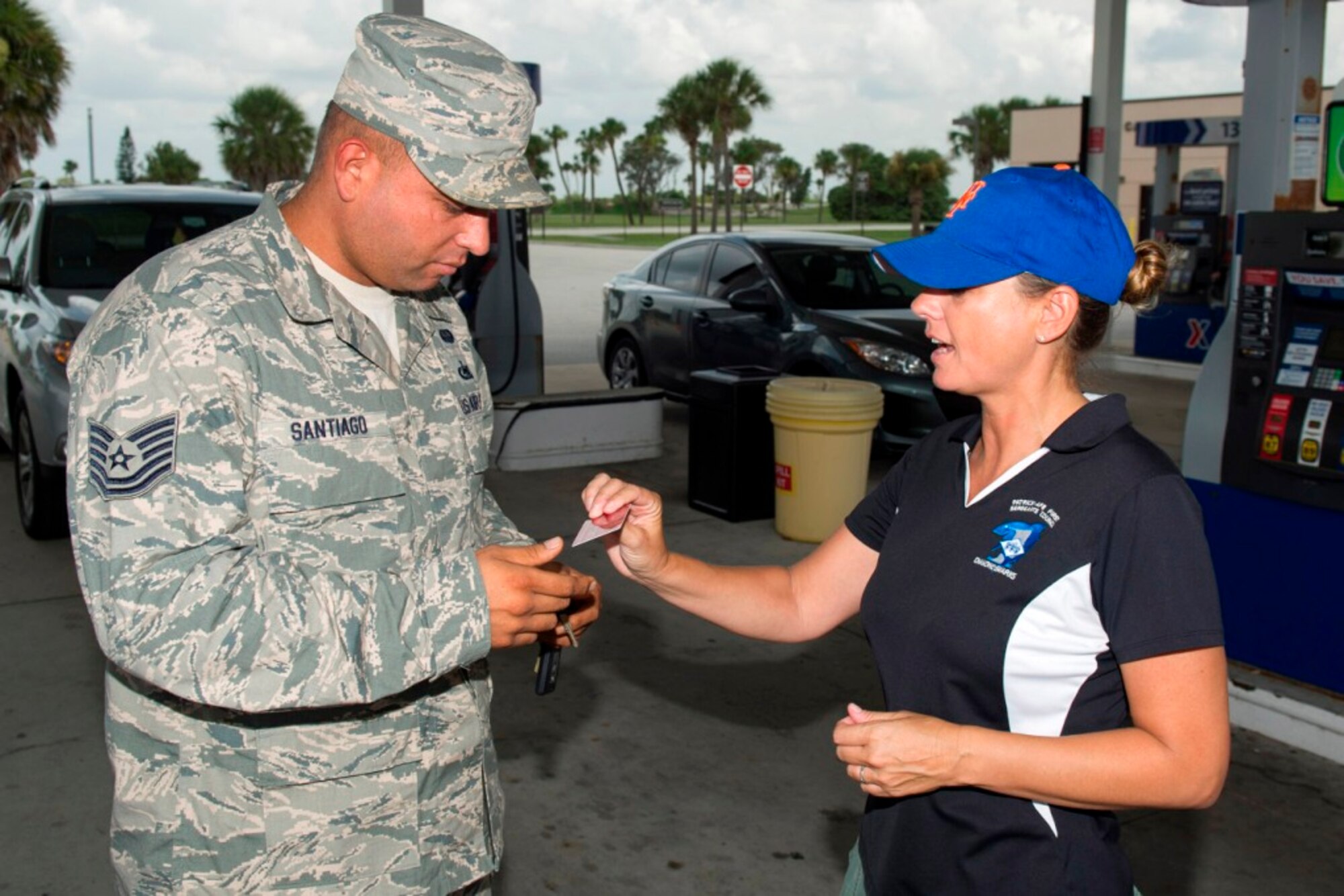 Tech. Sgt. Gilberto Santiago, Jr., 920th Rescue Wing accepts a $25 gas card from Master Sgt. Kim Melton, 45th Operations Group first sergeant, during a "Random Acts of Kindness" day that the Space Coast first sergeants took part in at the Express, formally known as Shoppette, at Patrick Air Force Base, Fla., July 24, 2013. (U.S. Air Force photo/Cory Long) (Released)