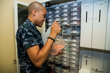 Petty Officer 2nd Class Daniel Nunez, Naval Health Clinic Charleston hospital corpsman, refills the ScriptPro automatic prescription filler in the NHCC pharmacy, July 29, 2013, at Joint Base Charleston - Weapons Station, Goose Creek, S.C. NHCC provides quality healthcare services for approximately 12,000 beneficiaries throughout the LowCountry, including a sick call clinic for Sailors assigned to the Weapons Station. (U.S. Air Force photo/ Senior Airman George Goslin)