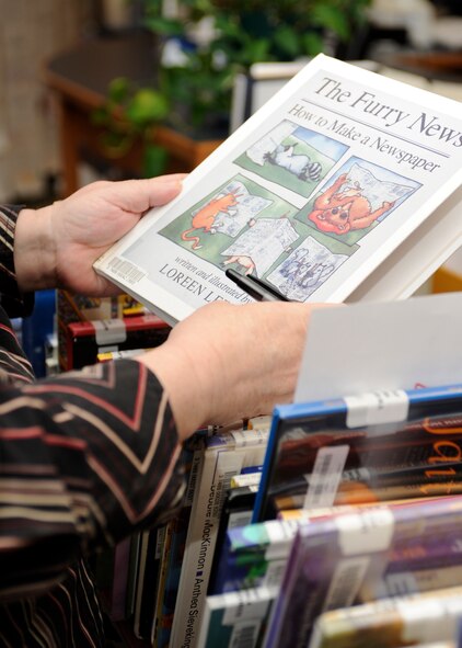 Jeanne Stoltenburg, 28th Force Support Squadron Holbrook Library director, evaluates a book while sorting through titles seldom checked out in the library at Ellsworth Air Force Base, S.D., July 30, 2013. The library’s inventory must be downsized periodically to make room for more popular material. (U.S. Air Force photo by Airman 1st Class Ashley J. Thum/Released)