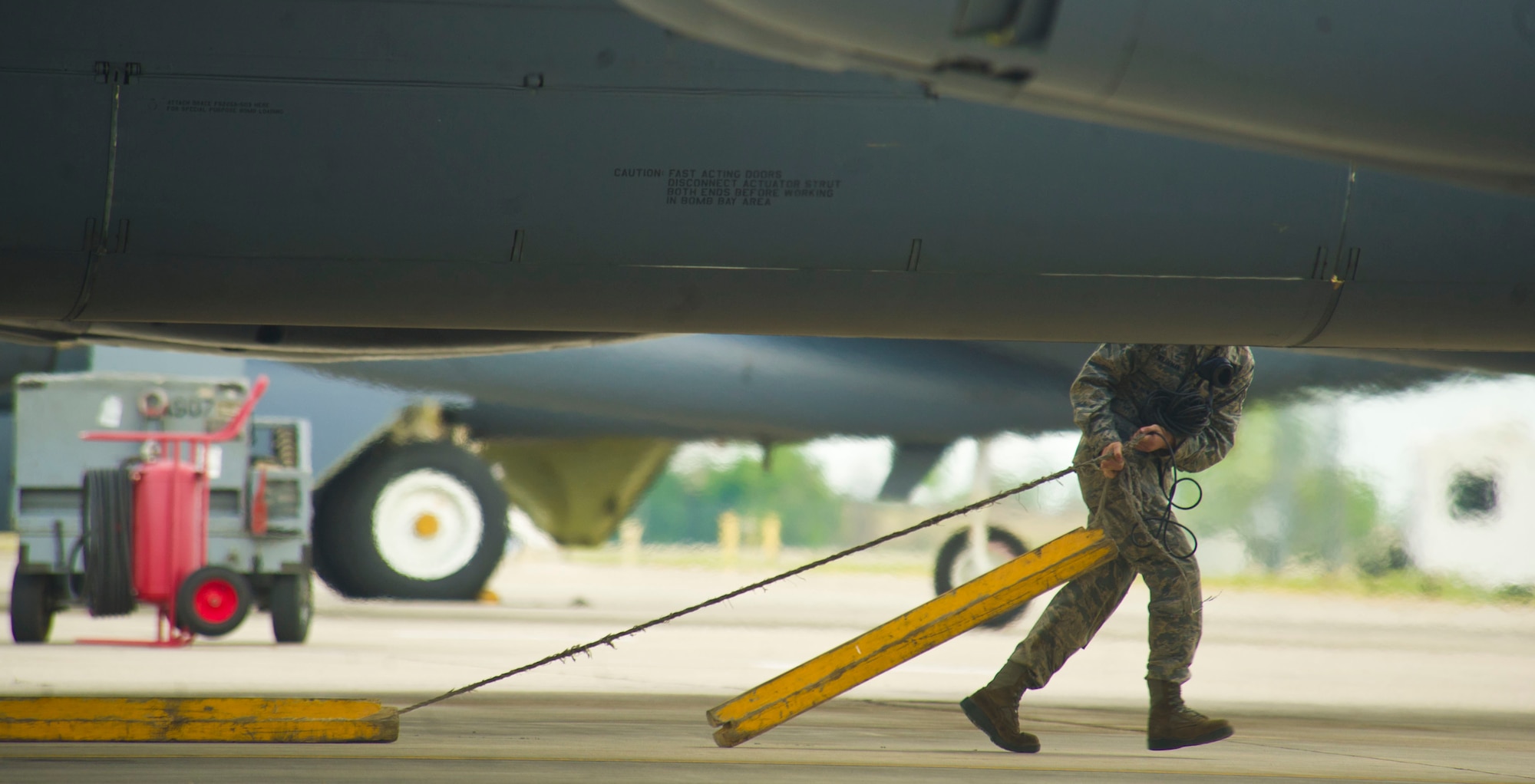 An Airman assigned to the 5th Aircraft Maintenance Squadron pulls chocks on a B-52H Stratofortress before take-off at Minot Air Force Base, N.D., July 25, 2013. The 5th AMXS consists of two aircraft maintenance unit specialist sections: The 23rd and 69th AMU, with a total of 237 maintenance professionals spanning across six Air Force specialties including Communications/Navigation, Instruments/Flight Controls, Electronic Counter Measures, Jet Engine Mechanics, Hydraulics and Electrical/Environmental systems. (U.S. Air Force photo/Senior Airman Brittany Y. Auld)