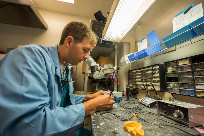 Navy Lt. Clay Miller, Naval Health Clinic Charleston dental officer, makes a temporary partial denture using a Therma-Knife July 29, 2013, at Joint Base Charleston - Weapons Station, Goose Creek, S.C. NHCC provides quality healthcare services for approximately 12,000 beneficiaries throughout the LowCountry, including a sick call clinic for Sailors assigned to the Weapons Station. (U.S. Air Force photo/ Senior Airman George Goslin)