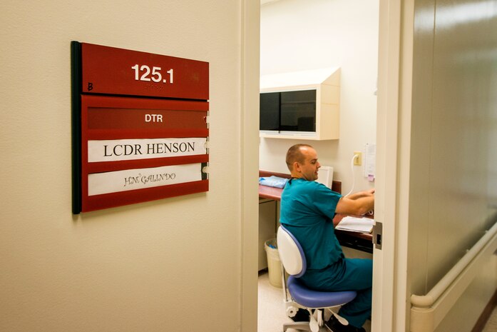 Lt. Cmdr. Joshua Henson, Naval Health Clinic Charleston senior dental executive, waits in his office before beginning an exam July 29, 2013, at Joint Base Charleston - Weapons Station, Goose Creek, S.C. NHCC provides quality healthcare services for approximately 12,000 beneficiaries throughout the LowCountry, including a sick call clinic for Sailors assigned to the Weapons Station. (U.S. Air Force photo/ Senior Airman George Goslin)