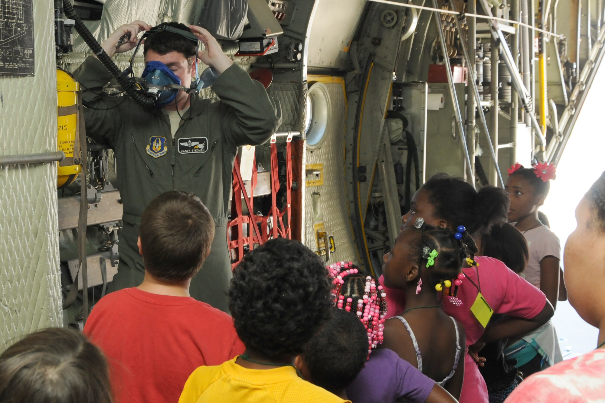 YOUNGSTOWN AIR RESERVE STATION, Ohio--Air Force Captain Casey Stedman dawns an emergency respirator for children visiting the base from the Kids by the Riverside Day Care Center of Warren Ohio on 29 July 2013. The children toured the base on Friday, visiting the flight line for a guided C-130 tour and the Fire Department. Stedman is a pilot for the 773rd Airlift Squadron. U.S. Air Force photo by TSgt. Jim Brock