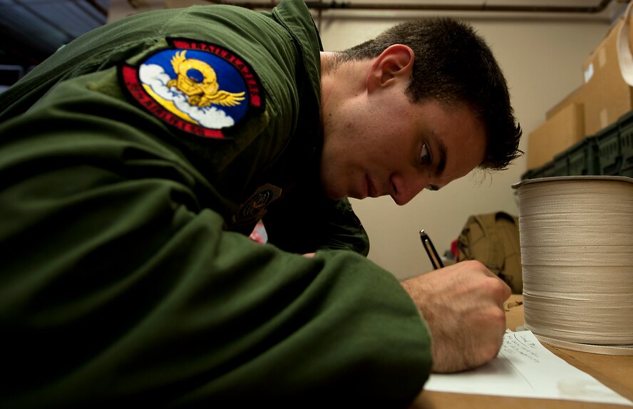 U.S. Air Force Senior Airman Calvin Cox, 39th Airlift Squadron, marks down discrepancies after incepting an airdrop bundle July 25, 2013, during a recertification class at Dyess Air Force Base, Texas. With limited funds available to keep the 317th Airlift Group flying, leadership within the organization found a way to ensure 45 Airmen behind the scenes stay certified to keep the C-130s in the air -all while saving $85,000, by sending instructors here to teach required courses. (U.S. Air Force photo by Airman 1st Class Damon Kasberg/Released)