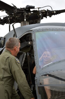 Chief Master Sgt. Mike Flake, 943rd Rescue Group, Davis-Monthan Air Force Base, Ariz., explains rescue operations to a young visitor sitting in an HH-60G Pave Hawk helicopter during the 304th Rescue Squadron reunion picnic at Portland International Airport, Ore., July 28, 2013. The 304th Rescue Squadron and 943rd Rescue Group are geographically separated units of the 920th Rescue Wing, Patrick Air Force Base, Fla.  (U.S. Air Force photo/Tech. Sgt. Anna-Marie Wyant)