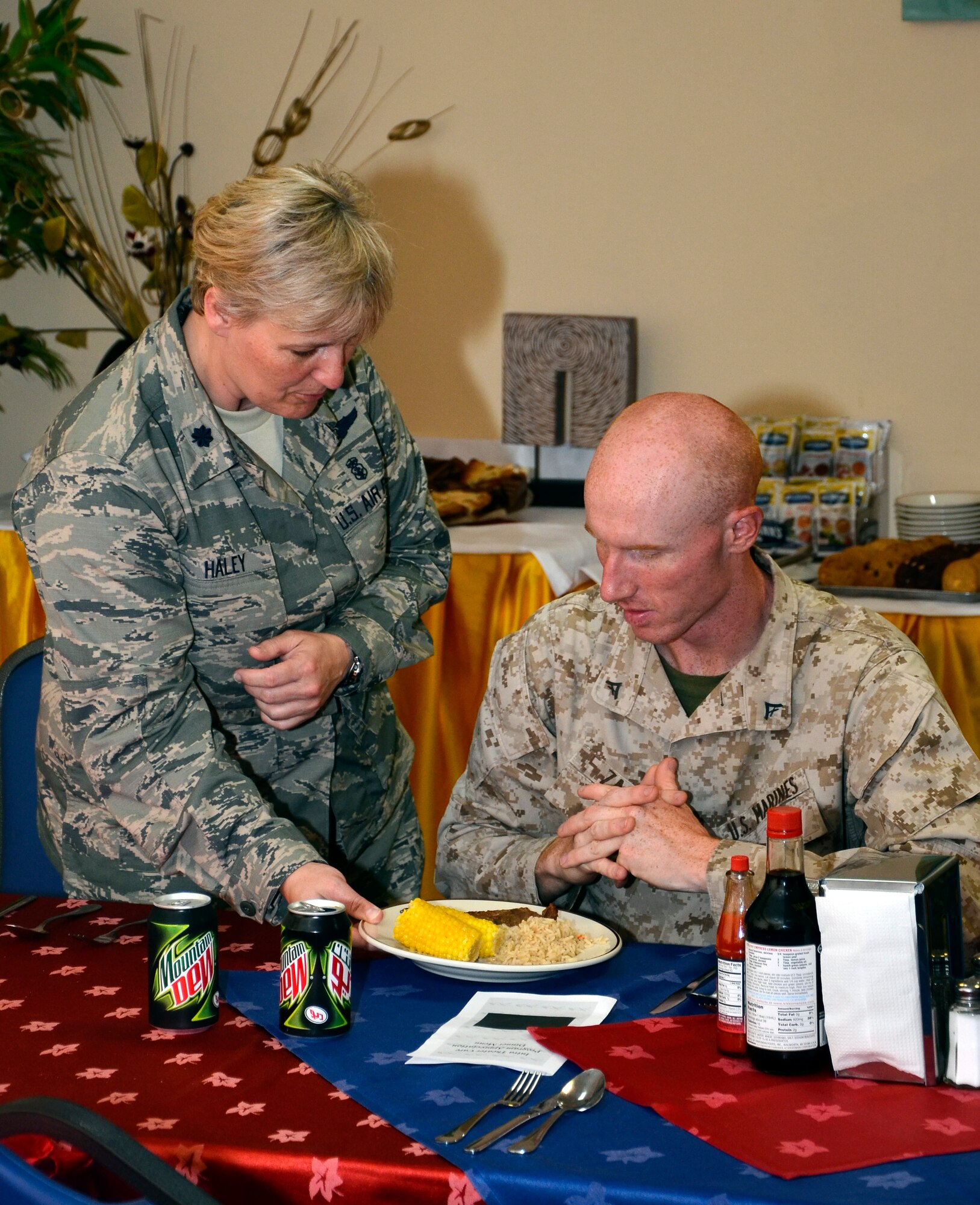 U.S. Air Force Lt. Col. Rosemary Haley serves dinner to U.S. Marine Corps Lance Cpl. Matt Zager during a monthly Intra-Theater Care Program meal served in the Manhattan Dining Facility at the 379th Air Expeditionary Wing in Southwest Asia, July 17, 2013. Haley is the 379th Expeditionary Medical Group deputy commander and Zager is an ITCP patient. (U.S. Air Force photo/Senior Airman Benjamin Stratton)