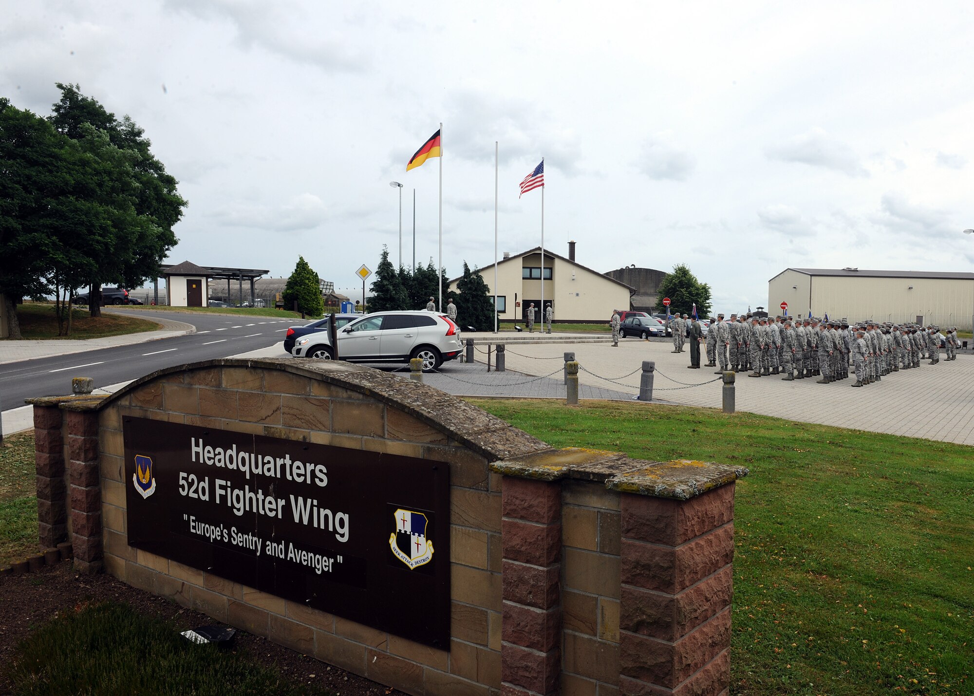 SPANGDAHLEM AIR BASE, Germany – Representatives from several base units stand in formation as members of the honor guard prepare to lower the U.S. and German flags at a new retreat ceremony July 29, 2013. This is the base-wide retreat ceremony this year, and it is intended to reinforce military traditions, customs and courtesies. (U.S. Air Force photo by Staff Sgt. Daryl Knee/Released)