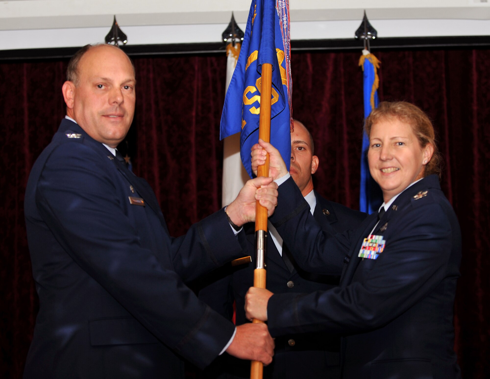 U.S. Air Force Col. Jeffrey Ullmann, 18th Mission Support Group commander, passes the guidon to Col. Kathleen Weatherspoon, 18th Force Support Squadron commander, during a change of command ceremony at the Rocker NCO Club on Kadena Air Base, Japan, July 30, 2013. Weatherspoon was the chief, Service Operations Division for the Armed Forces Entertainment, Pentagon, before assuming command. The 18th FSS provides community wellness activities, military and civilian support during war and peacetime, professional and off-duty education and family and readiness support programs to approximately 24,000 military, Department of Defense civilian, contractor and family members that comprise Team Kadena. (U.S. Air Force photo by Naoto Anazawa/Released)