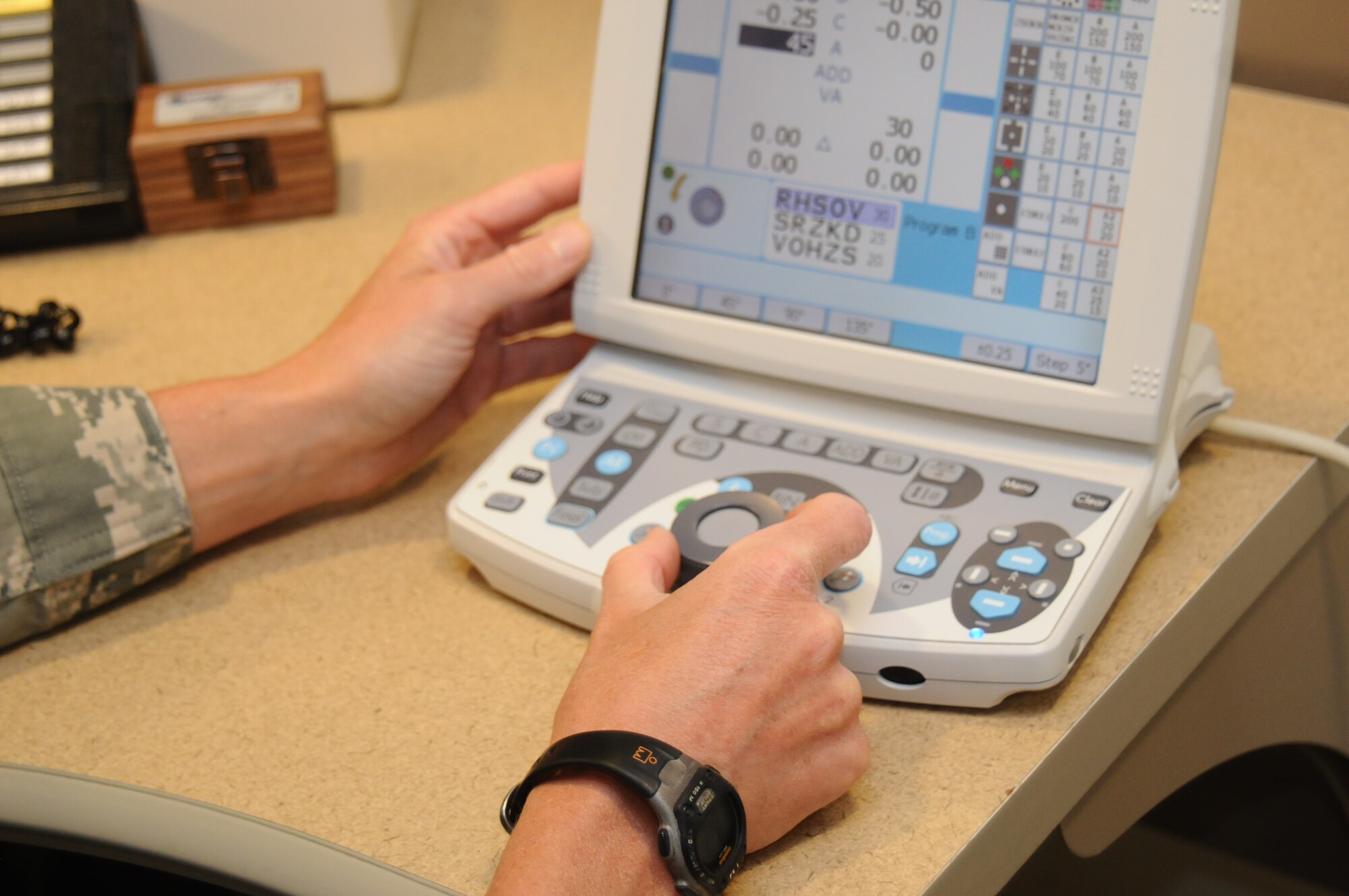 Lt. Col. Christine Stabile, 36th Medical Support Squadron commander, uses a refractor to determine a prescription for eyeglasses July 31, 2013, on Andersen Air Force Base, Guam. The new system allows machines used in eye exams to synchronize electronically for a faster flow of data. (U.S. Air Force photo by Airman 1st Class Emily A. Bradley/Released)