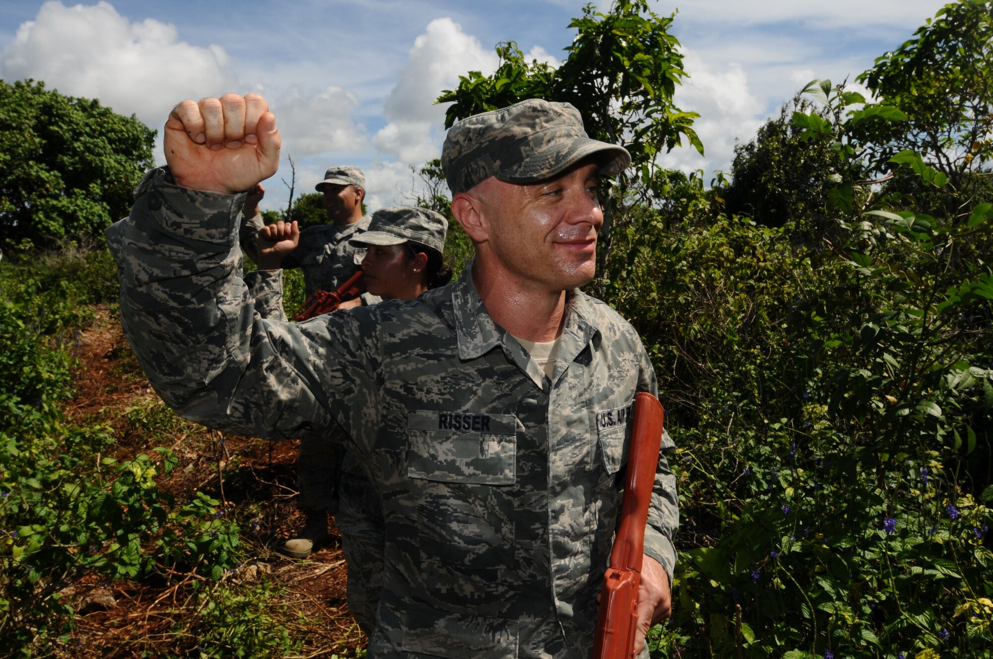 Tech. Sgt. Mathew Risser, 36th Civil Engineer Squadron safety and security representative, halts Airmen behind him during a foot patrol July 29, 2013, on Northwest Field, Guam. Dismounted operations training is a requirement prime Base Emergency Engineer Force Airmen have to complete to meet their deployment readiness standards. (U.S. Air Force photo by Airmen 1st Class Emily A. Bradley/Released)