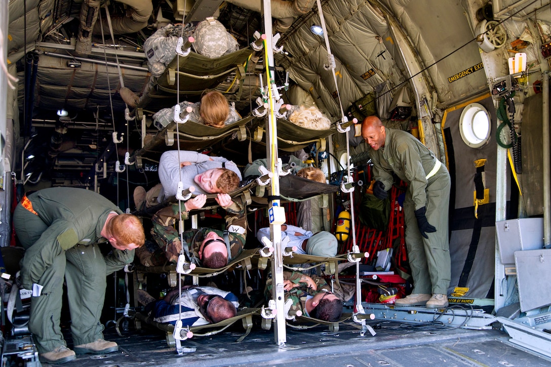 Air Force Tech. Sgts. Nicholas Payne, left, and Kenneth Holiness prepare mock patients for aeromedical evacuation aboard a C-130 Hercules aircraft during Warrior and Global Medic exercises on Fort McCoy, Wis., July 27, 2013. Payne and Holiness are assigned to the 94th Aeromedical Evacuation Squadron, Dobbins, Air Reserve Base, Ga.
