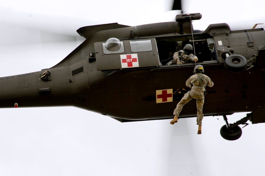 Crews hoise Army Staff Sgt. Nathaniel Shrouds into an HH-60M Black Hawk helicopter as part of aeromedical evacuation training during Warrior and Global Medic exercises on Fort McCoy, Wis., July 27, 2013. Shrouds is assigned to 1st Battalion, 214th Aviation Regiment, Fort Knox, Ky.