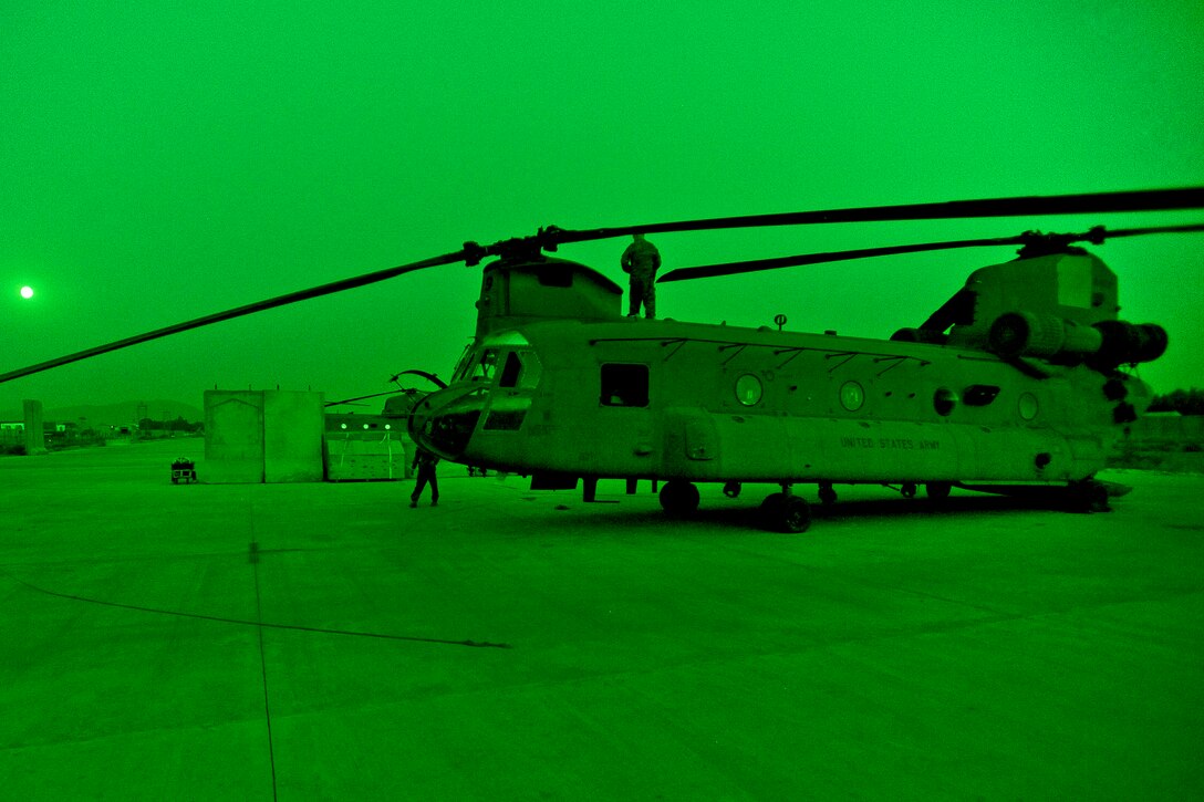 As seen through a night-vision device, the crew of a CH-47 Chinook helicopter performs a preflight inspection to prepare for the evenings missions on Forward Operating Base Fenty in Nangarhar province, Afghanistan, July 22, 2013. The soldiers are assigned to the 10th Mountain Division's Company B, 3rd Battalion, 10th General Support Avaition Battalion, 10th Combat Avaition Brigade.