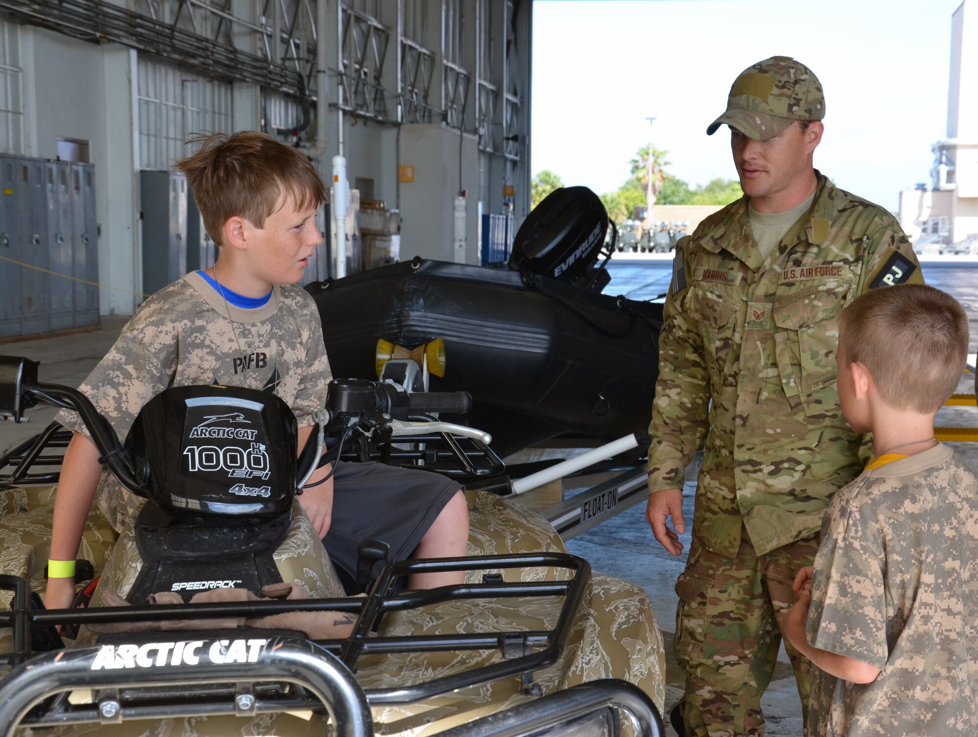 An Air Force Reserve pararescueman from the 308th Rescue Squadron answers kids’ questions about an all-terrain vehicle during the Kids Understanding Deployment Operations event at Patrick Air Force Base June 1, 2013. (U.S. Air Force photo/Tech. Sgt. Anna-Marie Wyant)
