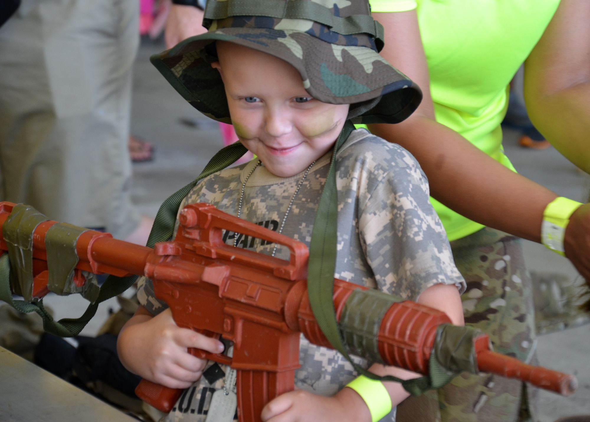 An Air Force-dependent child holds a dummy rifle during the Kids Understanding Deployment Operations event at Patrick Air Force Base June 1, 2013. (U.S. Air Force photo/Tech. Sgt. Anna-Marie Wyant)