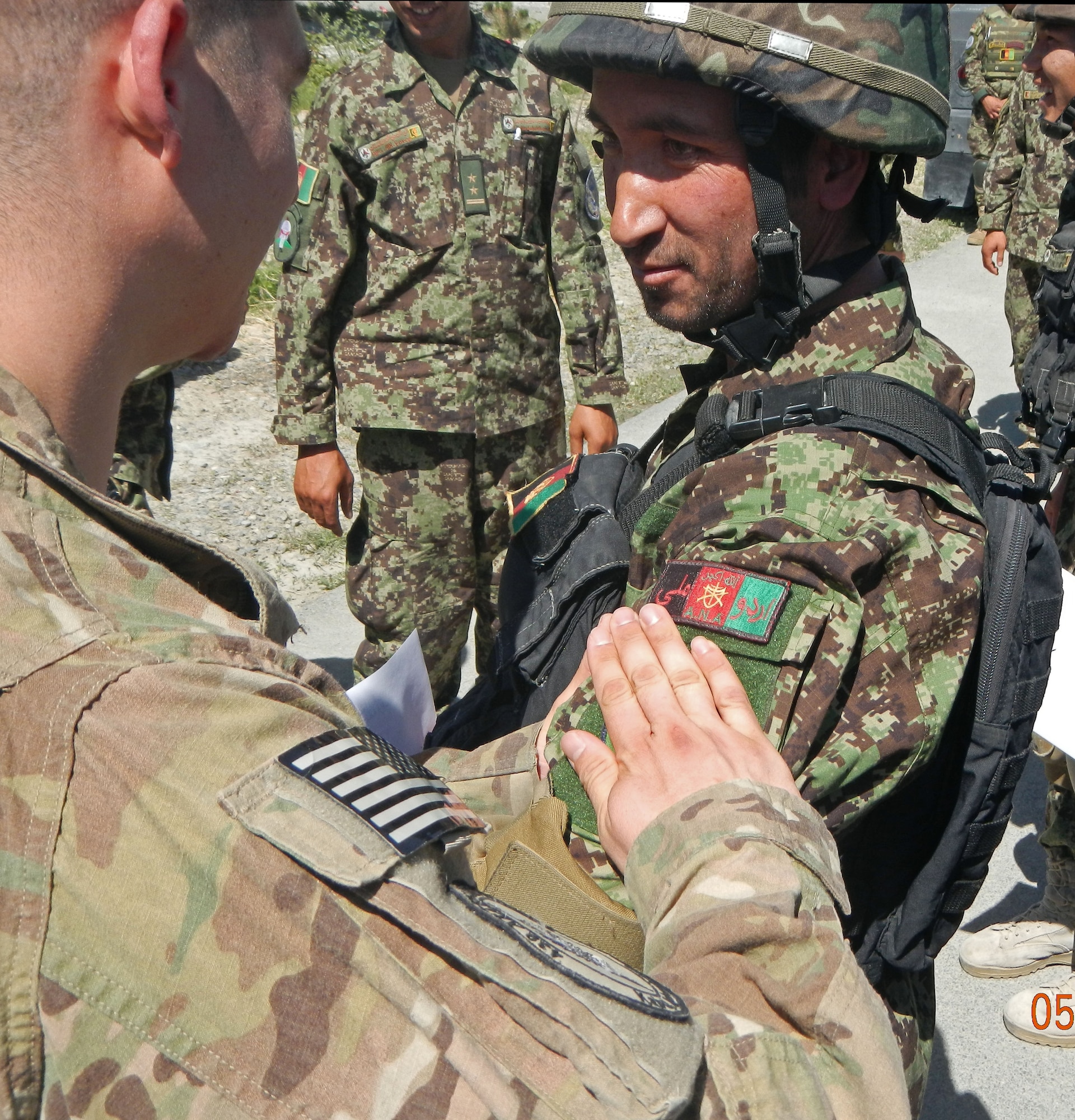United States Air Force Capt. Michael Morriss, NATO Air Training Command-Afghanistan security forces advisors, gives a new Quick Reaction Force graduate his QRF patch in a ceremony May 29, 2013 at Kabul International Airport, Afghanistan. Fourteen AAF members of the KAW QRF Company graduated from a 50-hour Ground Combat Skills Course. The graduation marked the completion of advanced upgrade training for the members of the QRF Company. The team trained on numerous types of procedures including mounted and dismounted operations, military operations in urban terrain, close quarters battle, building clearing, entry control point operations, combat lifesaver and advanced M-16 utilization. (U.S. Air Force photo/Staff Sgt. Chris McAleer)