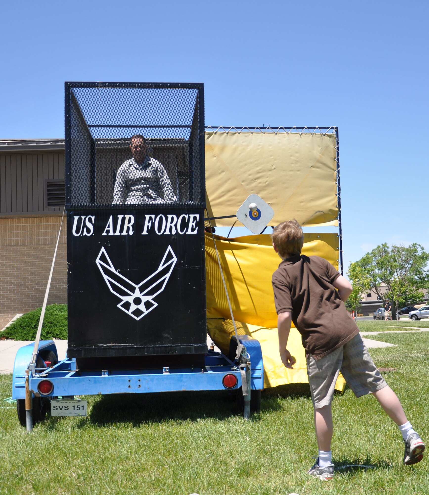 Col. Mark S. Larson, commander, 931st Air Refueling Group watches as a ball strikes the target that will result in his imminent drenching during the 931st ARG family day, at the Kansas Air National Guard's dining facility, June 2. Airmen were invited to bring their family members to the event on the second day of the June unit training assembly. (Air Force photo by Master Sgt. Brannen Parrish)