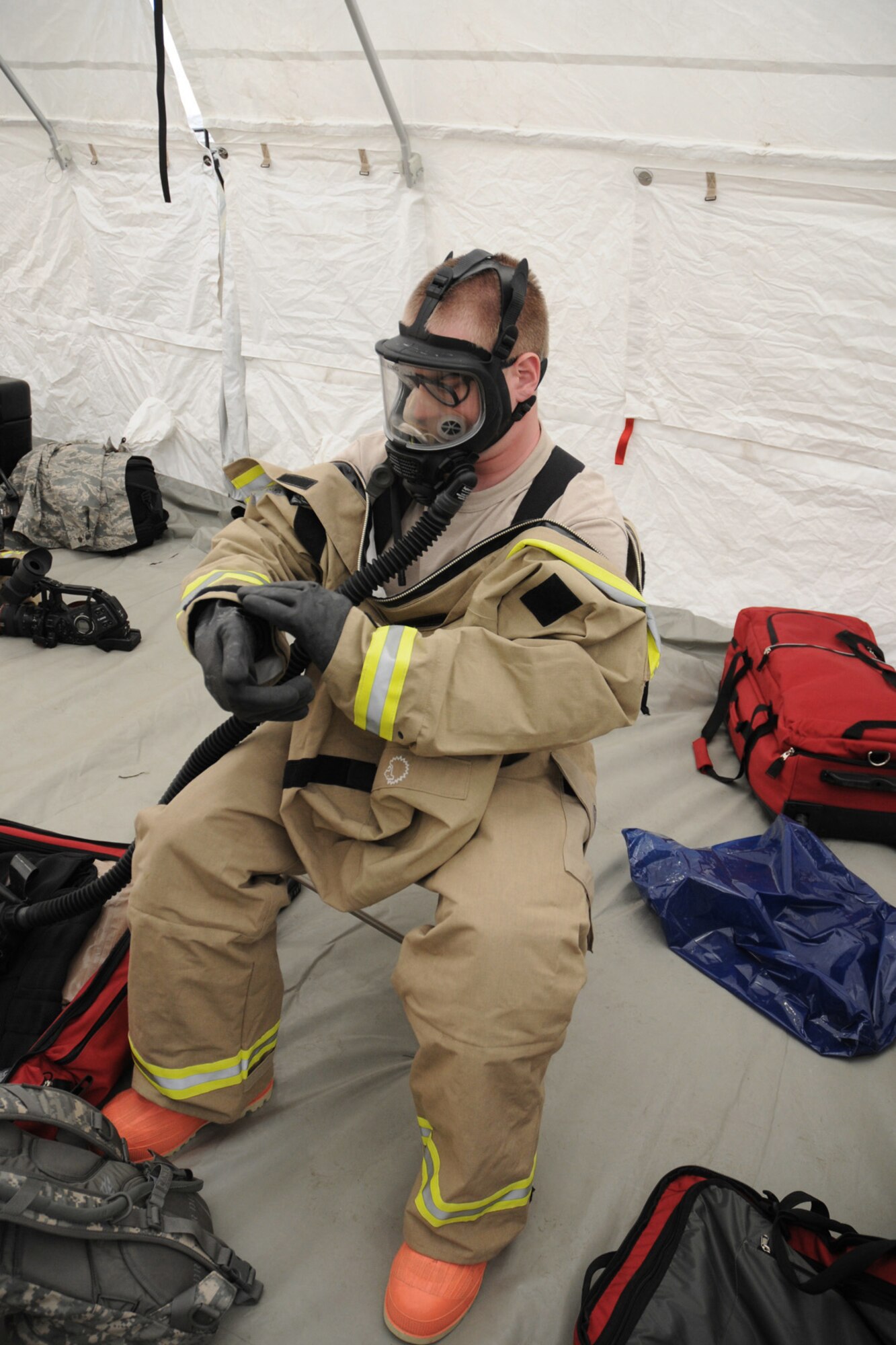 Staff Sgt. Ryan King, FSRT team member, dawns his Lion MT94 Chemical Suit to prepare to enter the scenario's "hot zone" at Camp Ashland, Nebraska on May 15, 2013. These suits add 25 degrees to the outside temperatures, hinder vision and limit movement, but they play a vital role in preparing the team for a real chemical environment.  (U.S. Air National Guard photo by Tech. Sgt. Sara M. Robinson/Released)