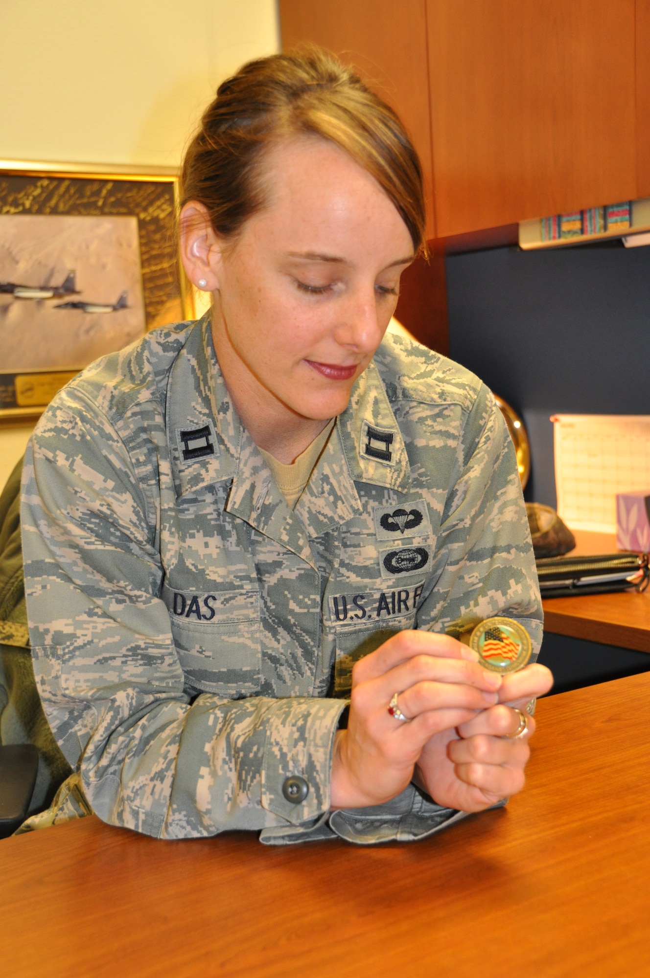 The only personal affect returned to Capt. N.C. Das from her husband's crash site was a coin, which honored the Sept. 11, 2001 victims with the words "We will never
forget" on one side and "United together in the fight against terrorism" on
the other side. She carries it with her every day. (U.S. Air Force/Capt. Ashley Conner)  
