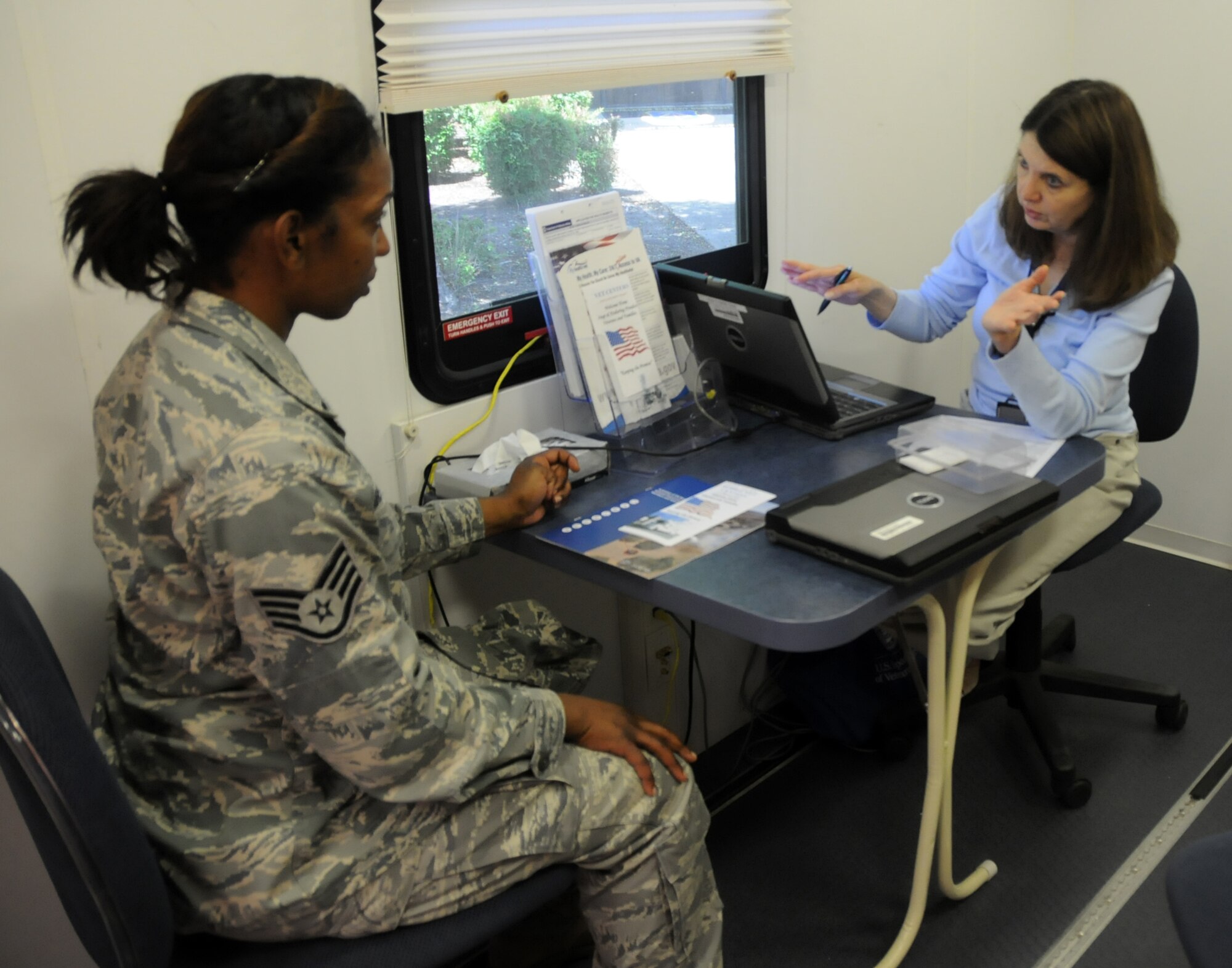 Ms. Clara Shockley (right), a clinical social worker from the Richmond Vet Center, gives information  about the benefits available for deployment injuries to Staff Sgt. Kristen Gregory (left), 192nd Supply Chain Management Systems technician. The Mobile Vet Center was present to provide services to veterans from the 192nd Fighter Wing, as part of the Yellow Ribbon Program at Langley Air Force base, June 1, 2013. (U.S. Air National Guard photo by Airman 1st Class Johnisa B. Roberts/Released)