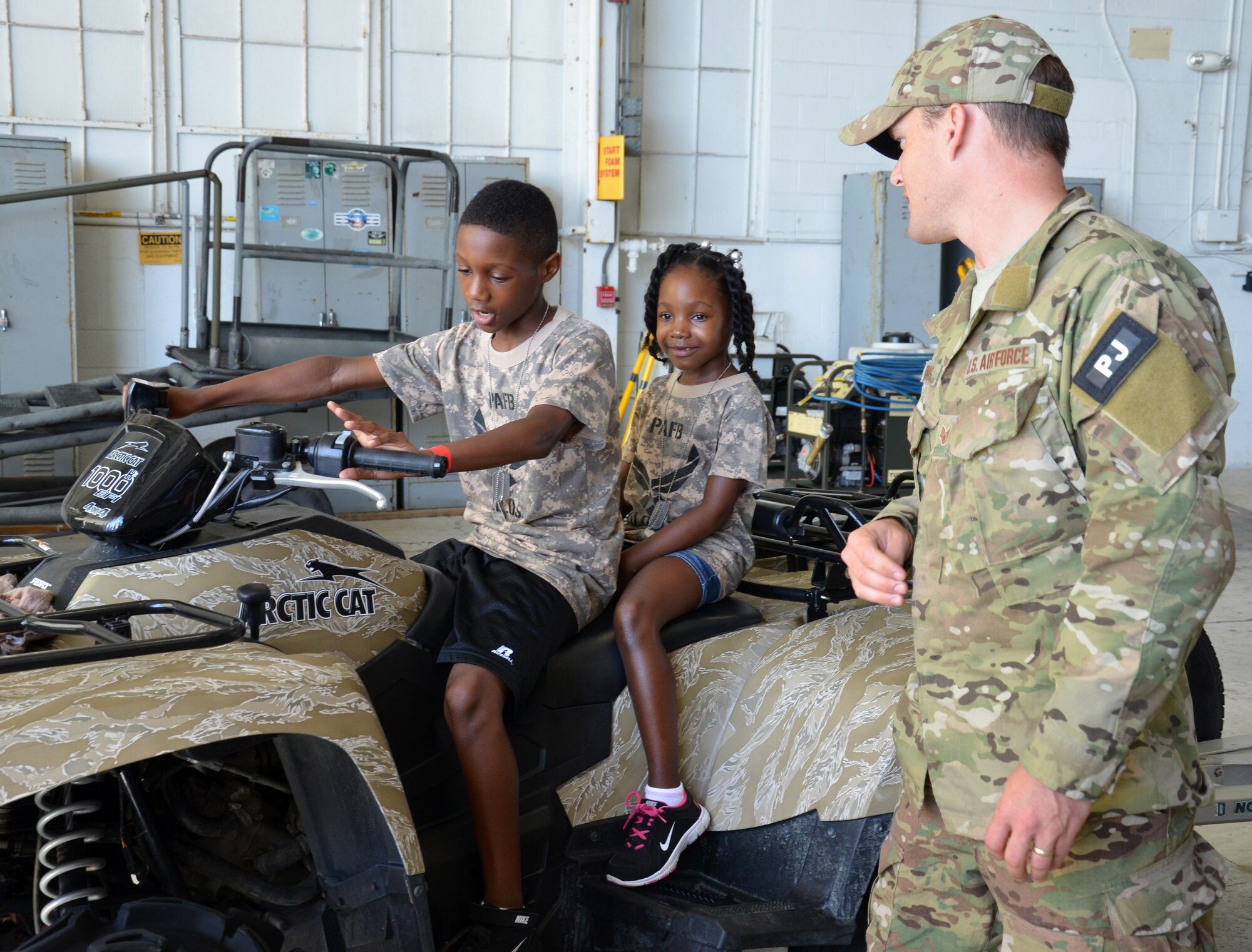 An Air Force Reserve Pararescueman from the 308th Rescue Squadron answers kids’ questions about an all-terrain vehicle during the Kids Understanding Deployment Operations event at Patrick Air Force Base June 1, 2013. (U.S. Air Force photo/Tech. Sgt. Anna-Marie Wyant)