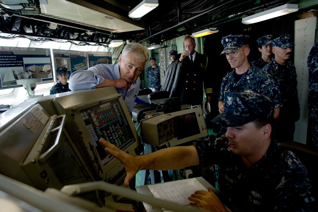 U.S. Defense Secretary Chuck Hagel listens to a sailor on the bridge of the USS Freedom in Singapore, June 2, 2013. Hagel toured the ship, addressed the crew and watched a demonstration of a waterborne mission.